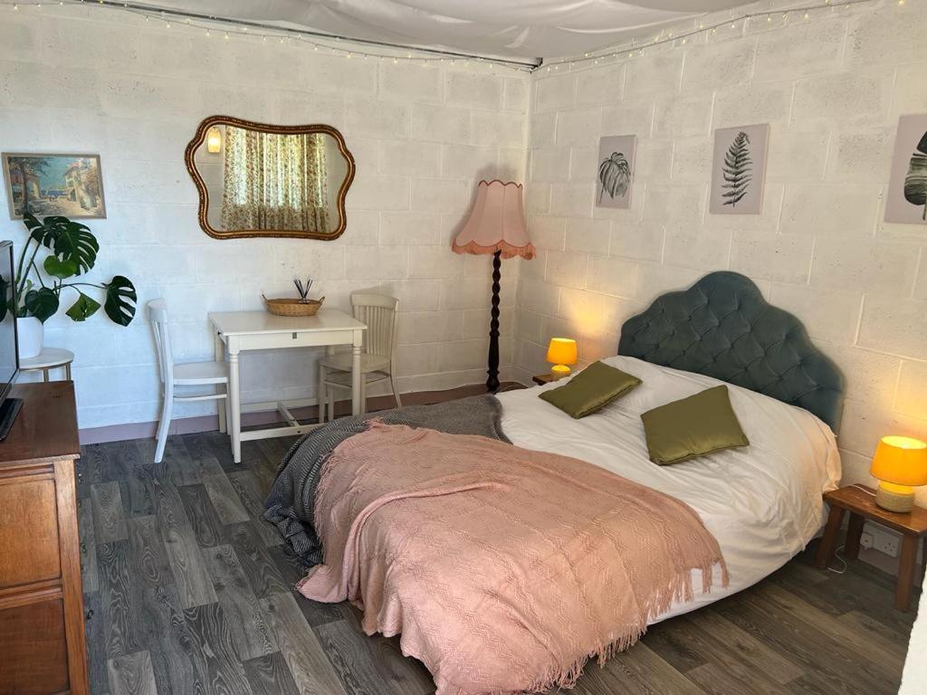 a bedroom with a bed and a table with a lamp at Number Four - The Old Stable Block in Wadebridge