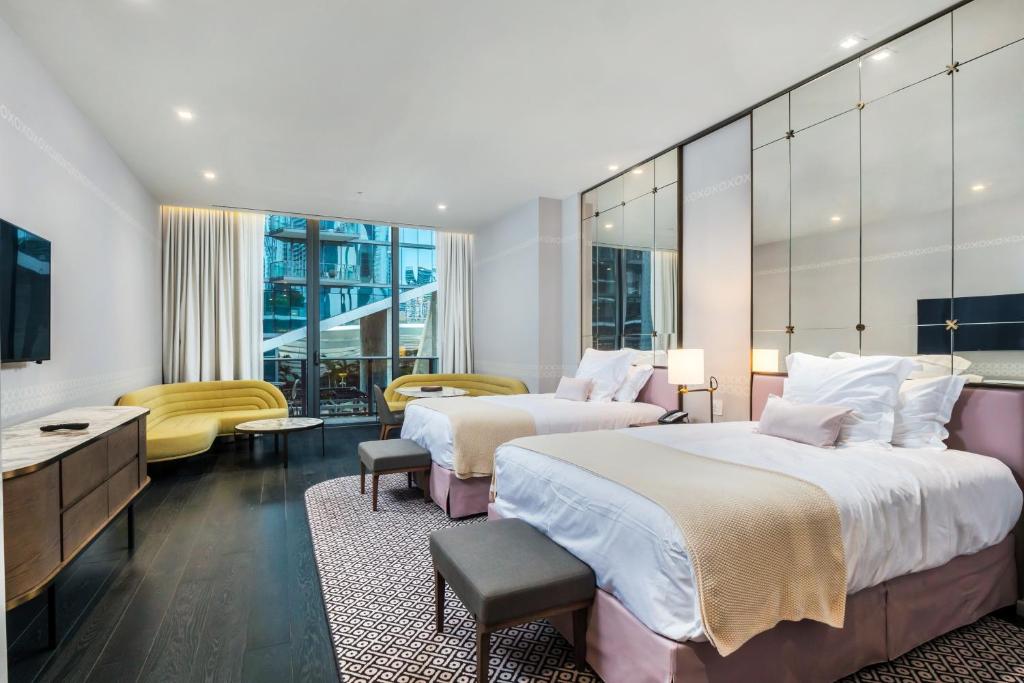 a hotel room with two beds and a television at Suites at SLS Lux Brickell managed by CE in Miami