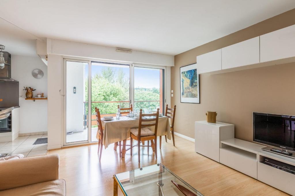 eine Küche und ein Wohnzimmer mit einem Tisch und Stühlen in der Unterkunft Appartement Georges - Welkeys in La Rochelle