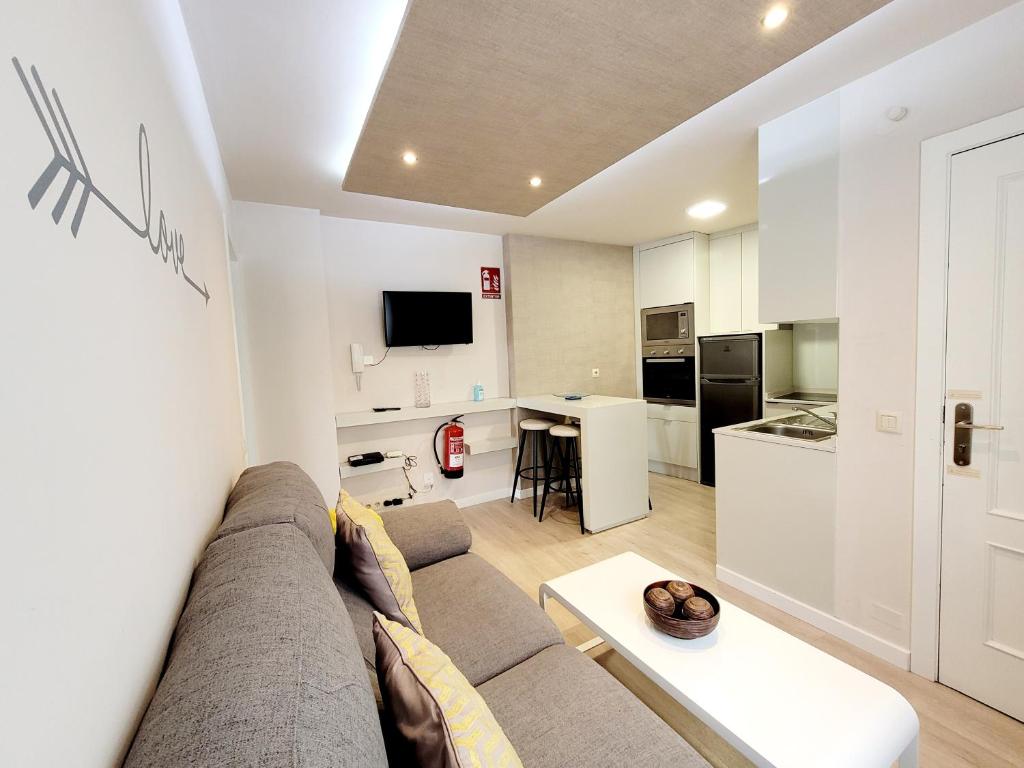 a living room with a couch and a kitchen at Acogedor apartamento a la entrada de camino portugués in Santiago de Compostela