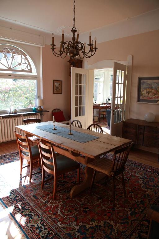 uma sala de jantar com uma mesa de madeira e cadeiras em Rosie's Place: Furnished Apartment with Style em Weinheim