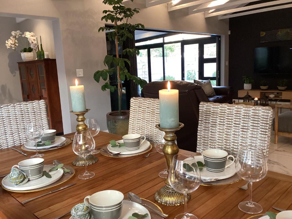 stół jadalny ze świecami, talerzami i krzesłami w obiekcie Villa Lyrique w Kapsztadzie