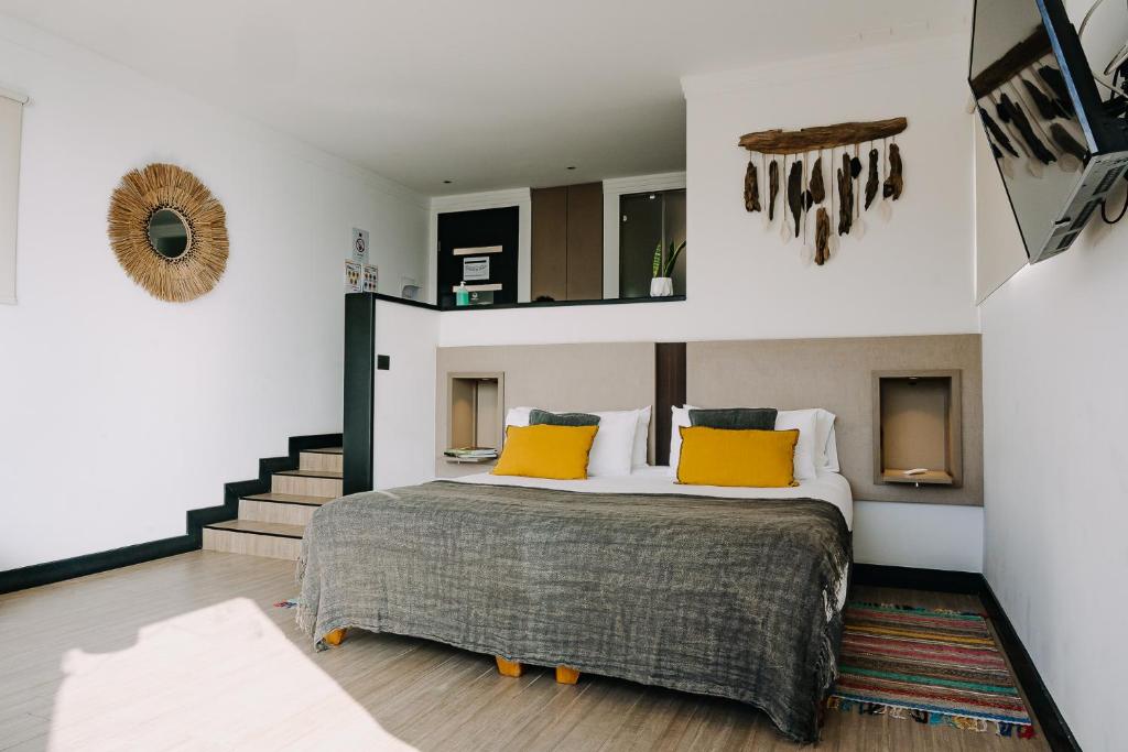 1 dormitorio con 1 cama grande con almohadas amarillas en Pura Lodge en Concepción