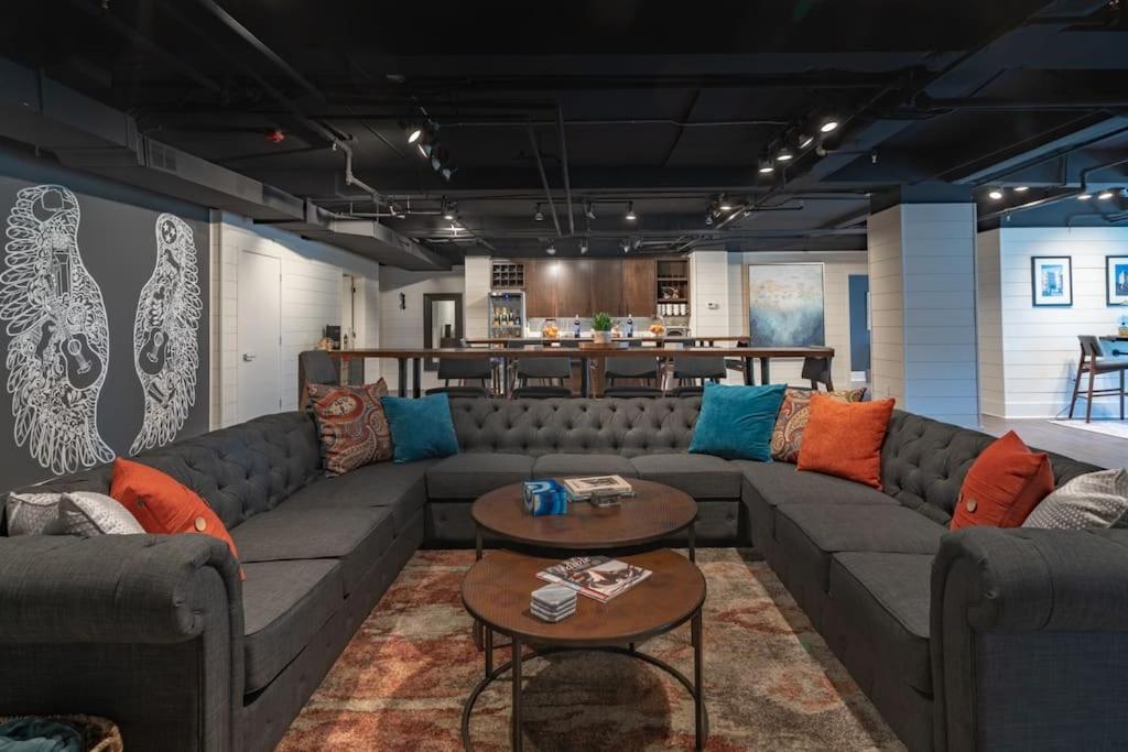 a living room with couches and tables and a bar at Contemporary flat at The Maddox in Nashville