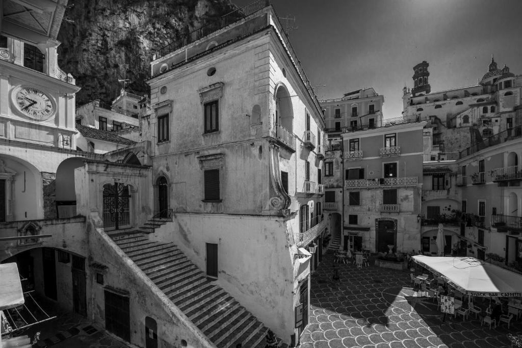 a black and white photo of a building with a clock at B&B Viacampo6 in Atrani