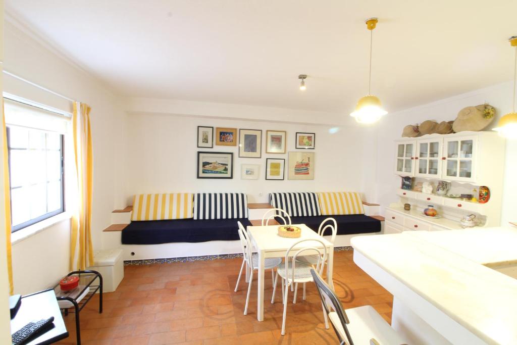 a living room with a couch and a table and chairs at Fisherman's Townhouse at Old Town in Albufeira