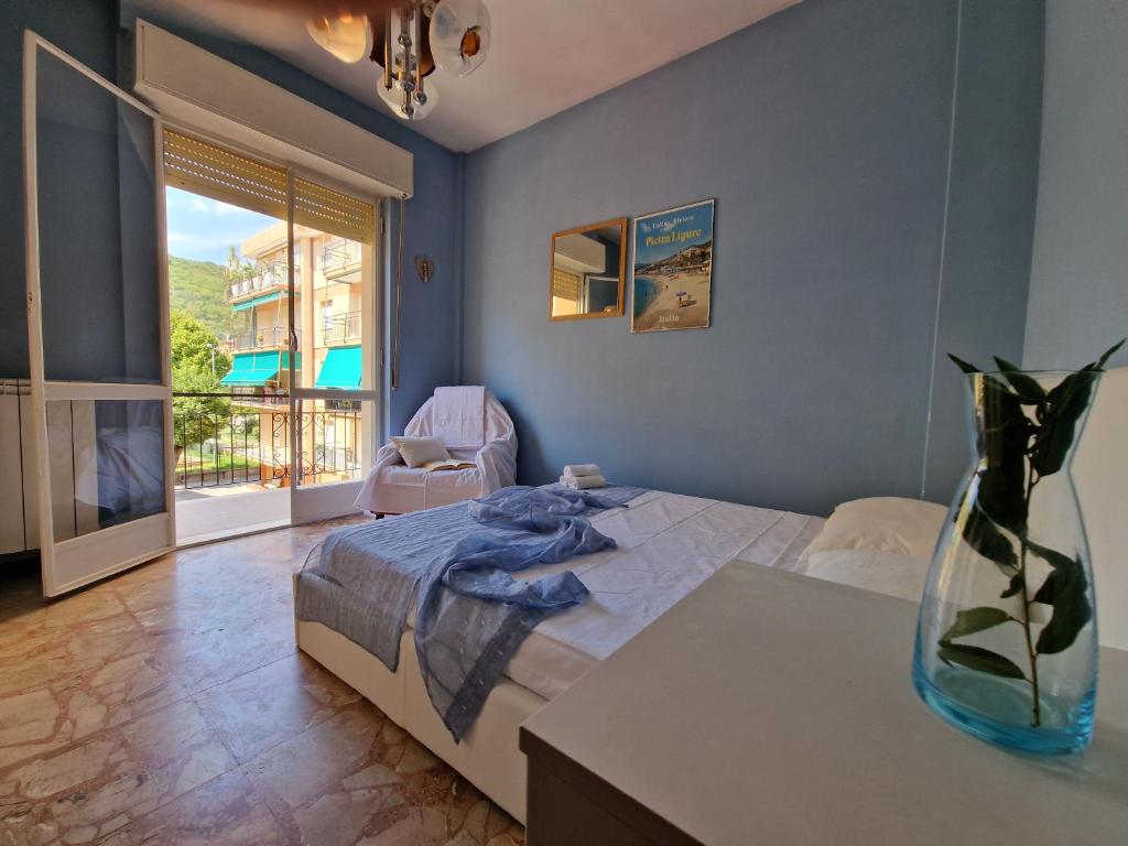 a bedroom with a bed and a vase on a table at [P.ZZA MARCONI] Bilocale per la vacanza al mare in Pietra Ligure