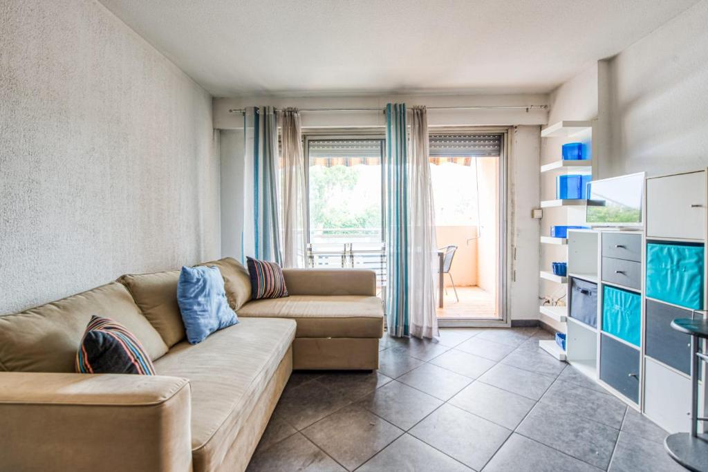 a living room with a couch and a large window at Appartement Bréguières - Welkeys in Antibes