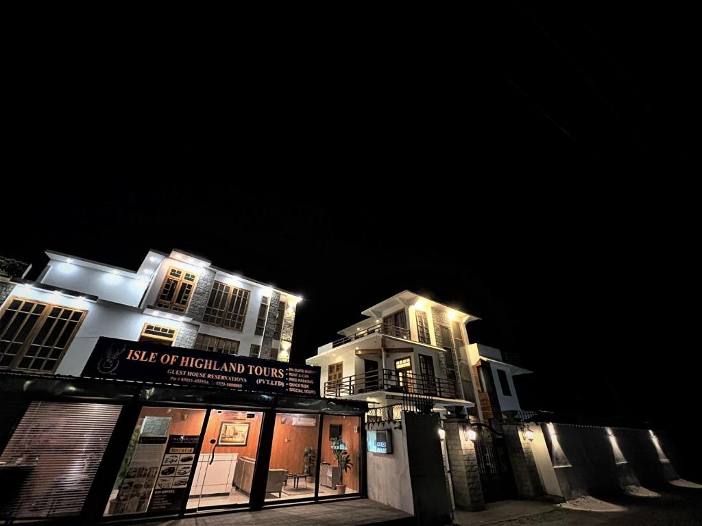 a building with a sign on it at night at ISLE OF HIGHLAND TOURS Guest House in Gilgit