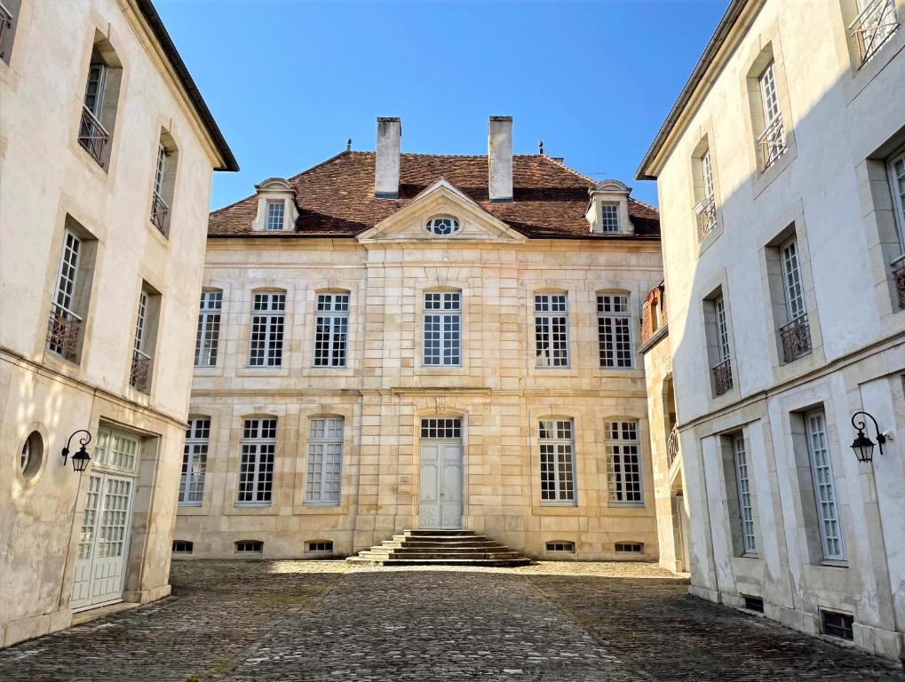 um grande edifício de pedra com escadas num pátio em Hôtel Particulier, Maison Jazey. em Semur-en-Auxois