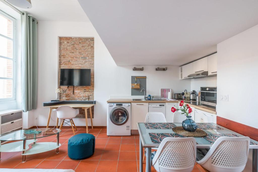 a kitchen and dining room with a table and chairs at Superb apartment located on the main square - Toulouse - Welkeys in Toulouse