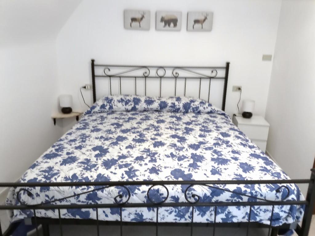 a bed with a blue and white comforter on it at La Cameretta in Barisciano