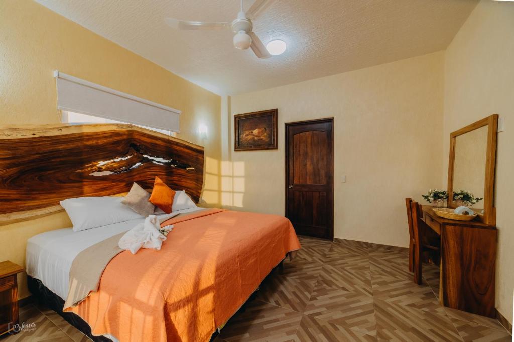 ein Hotelzimmer mit einem Bett, einem Schreibtisch und einem Zimmer in der Unterkunft Primavera Suites in Zihuatanejo