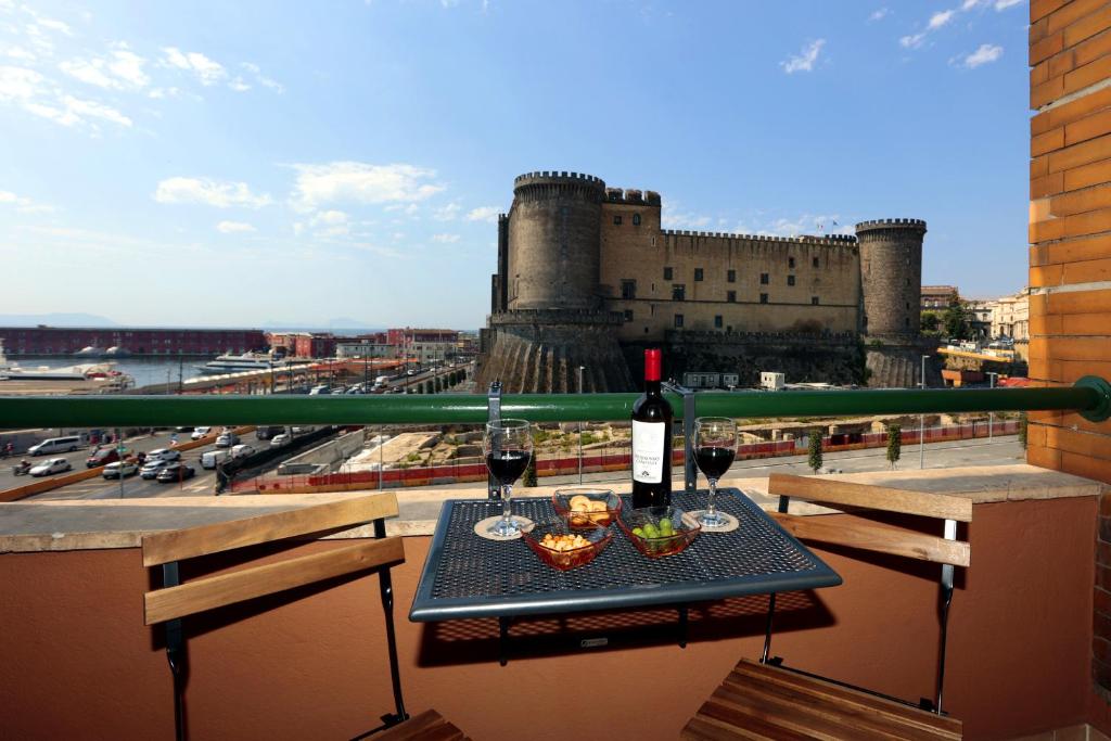 a table with two glasses of wine on a balcony at AnGiò holiday rooms in Naples