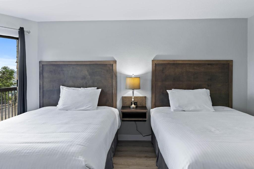 two beds sitting next to each other in a room at The Vista Inn in Kamloops
