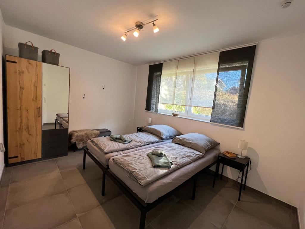 a bedroom with a bed and a large window at Neubau Ferienwohnung Winterscheid nahe zu Köln Bonn bis 4 Personen mit Netflix und mehr in Ruppichteroth