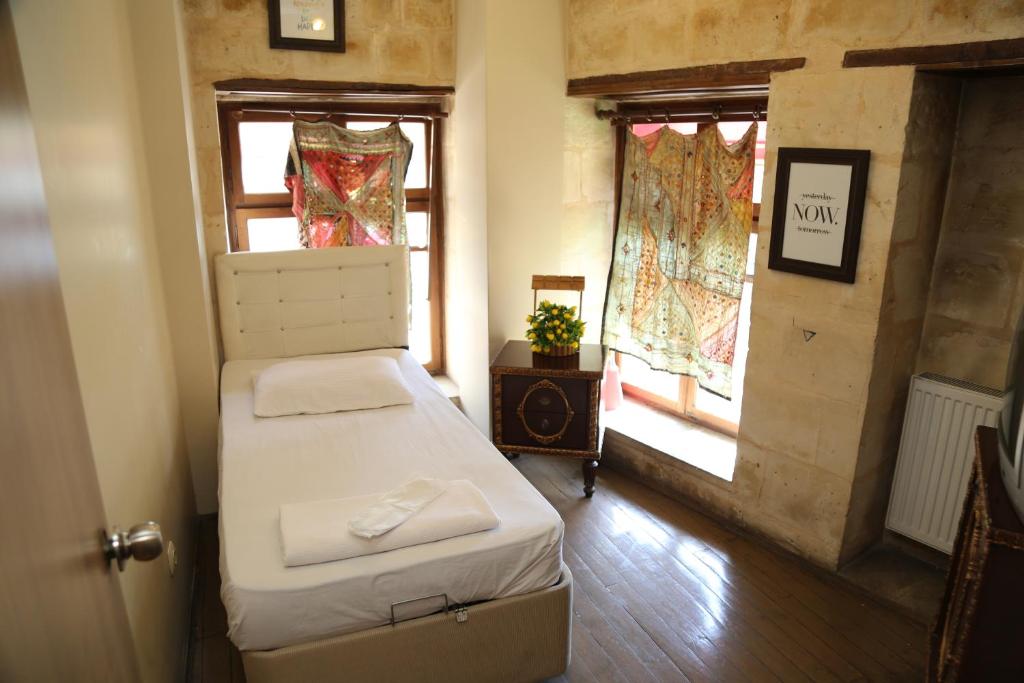 a small room with two beds and a window at KALE EVİ BUTİK OTEL in Şahinbey