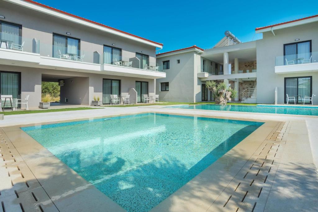 a swimming pool in front of a building at AlexMare Hotel Fourka in Skala Fourkas