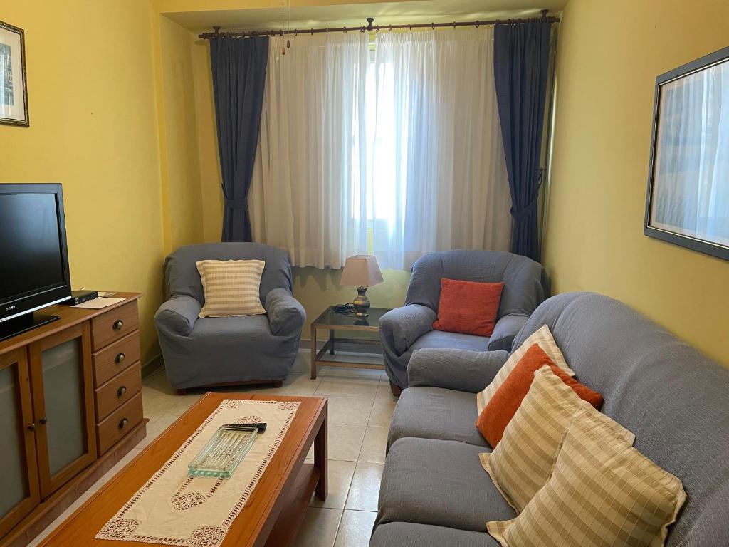 uma sala de estar com dois sofás e uma televisão em Apartamento economico a 100m de la playa ESTANCIA MINIMA 4 NOCHES em Póvoa do Caraminhal