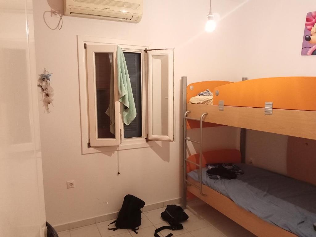 a bedroom with a bunk bed and a window at HOUSE 3Bedroom Maisonette ΕΞΟΧΙΚΟ Alyki PAROS 50m from BEACH ideal for families in Aliki