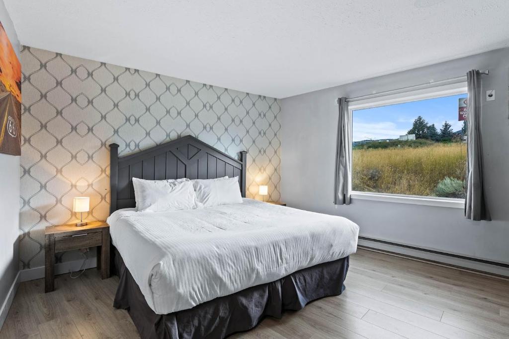 a bedroom with a large bed and a window at The Vista Inn in Kamloops