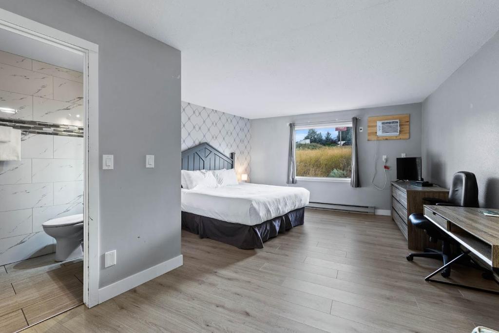 a bedroom with a bed and a desk and a piano at The Vista Inn in Kamloops