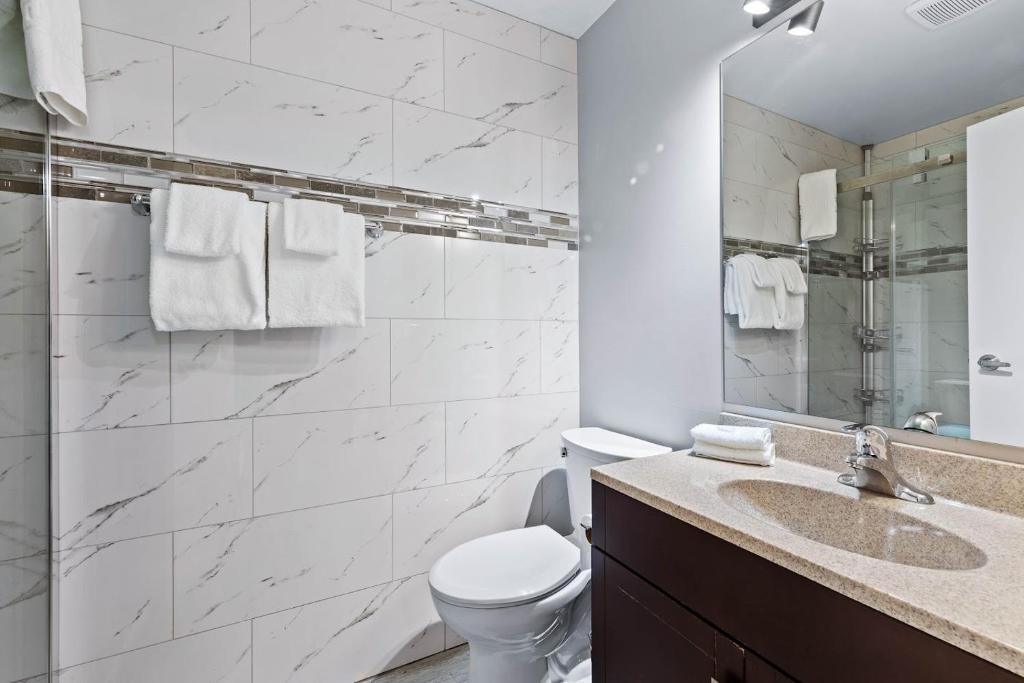 a bathroom with a toilet and a sink and a mirror at The Vista Inn in Kamloops