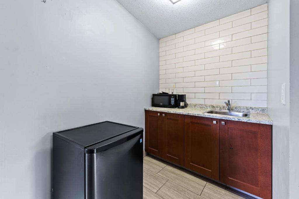 a kitchen with a sink and a refrigerator at The Vista Inn in Kamloops