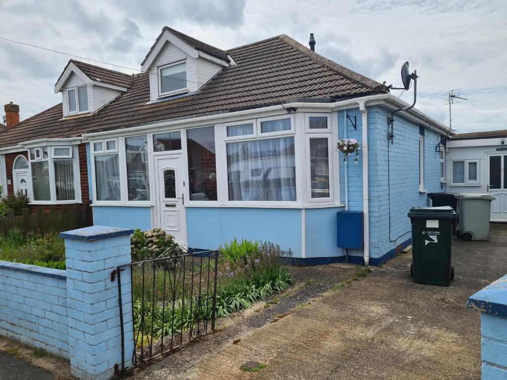 a blue house with a fence in front of it at 5 Berth bungalow in Mablethrorpe (Joe's Place) in Mablethorpe