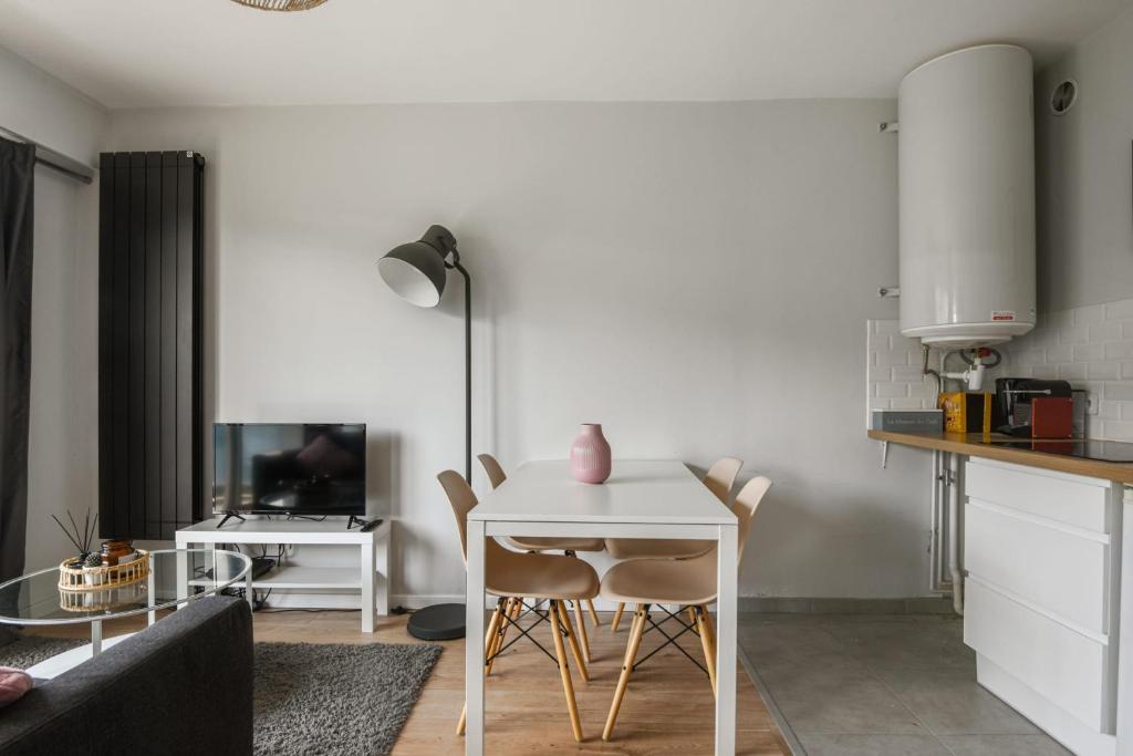 a living room with a white table and chairs at Beautiful apartment with a balcony in the heart of Lille - Welkeys in Lille