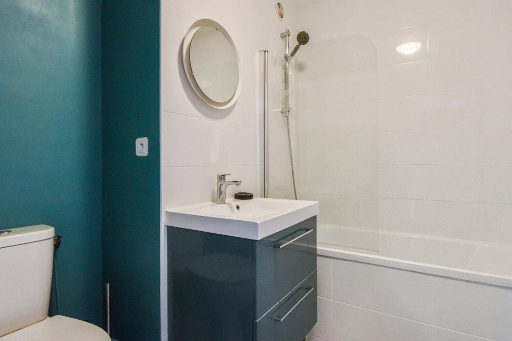 a bathroom with a sink and a mirror and a tub at Beautiful apartment with a balcony in the heart of Lille - Welkeys in Lille