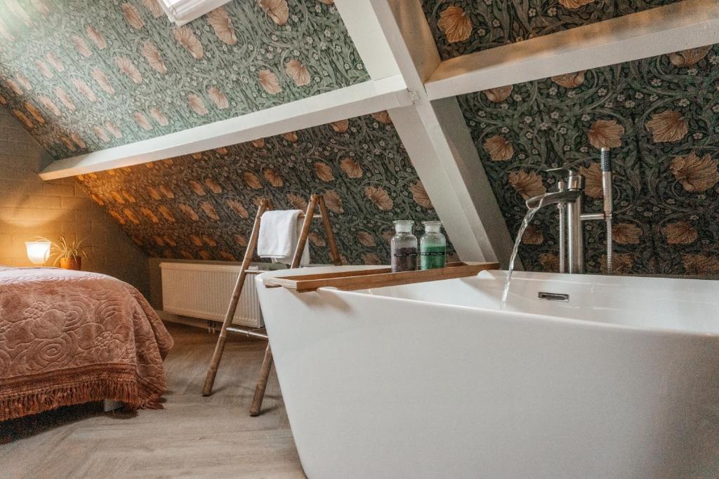 a bath tub in a room with a bedroom at Logement Cornelia - Tholen, Zeeland in Tholen