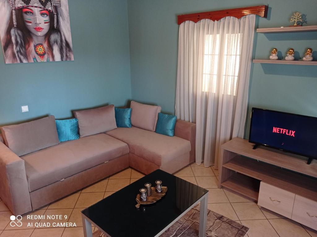 a living room with a couch and a tv at Bratis House in Vartholomio