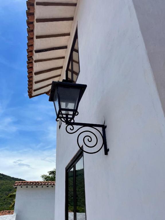 a light on the side of a white building at Hotel Boutique Posada Las Trampas in Honda