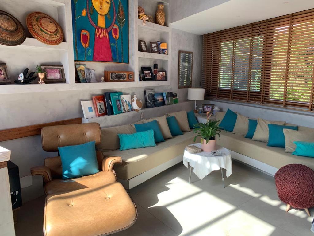 uma sala de estar com um sofá e almofadas azuis em Cobertura Duplex com piscina e Suítes Barão Vermelho em Morro de São Paulo