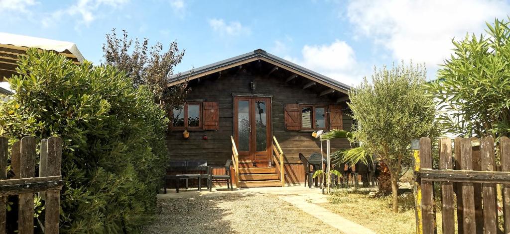 a wooden house with a wooden door and a fence at Chalet en bois "Le Libellule" in Sigean