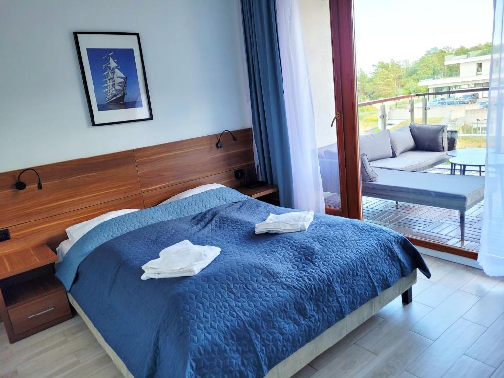ein Schlafzimmer mit einem blauen Bett mit zwei Handtüchern darauf in der Unterkunft Baltic Park 314 in Świnoujście