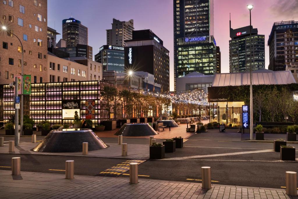 a city at night with tall buildings at Mövenpick Hotel Auckland in Auckland