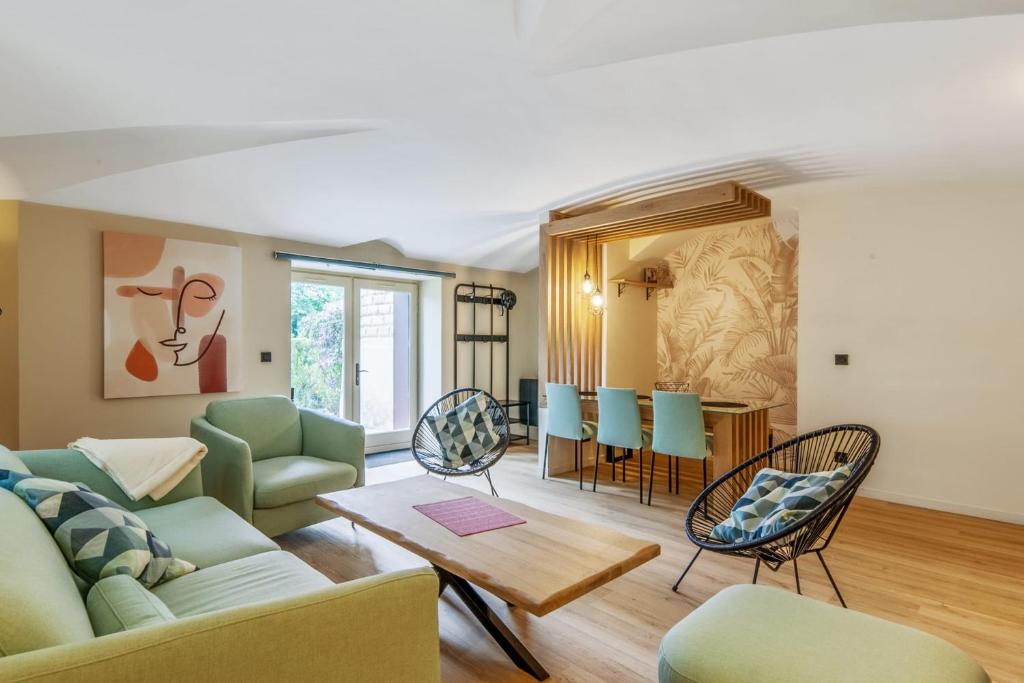 uma sala de estar com um sofá, cadeiras e uma mesa em Wonderful apartment in a château with a yard - Houlgate - Welkeys em Houlgate