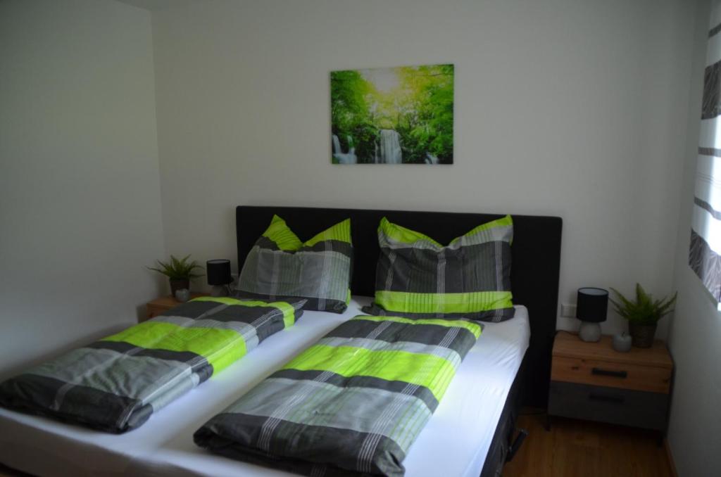 sypialnia z 2 łóżkami z zielonymi i szarymi poduszkami w obiekcie Zimmervermietung Familie Glatz w mieście Möderbrugg