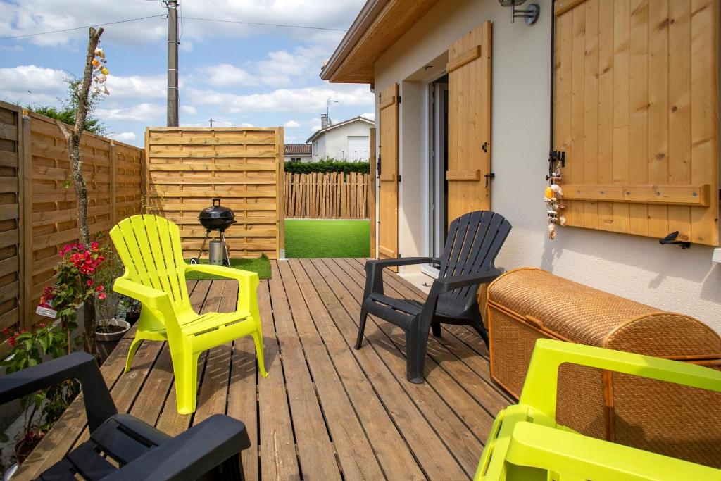 twee stoelen en een bank op een houten terras bij la p'tite vie là in Le Porge