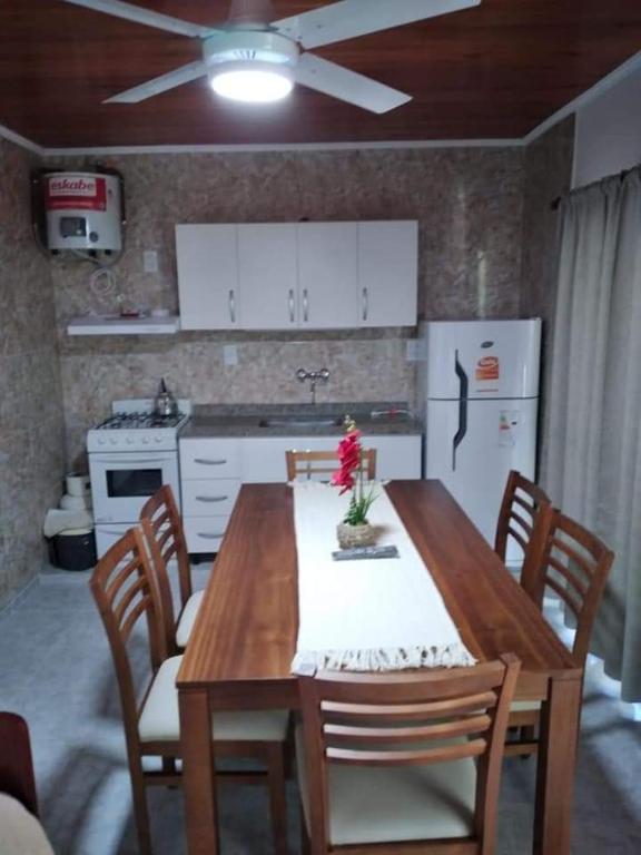 a kitchen with a wooden table with chairs and a refrigerator at Departamento Odi in Federación