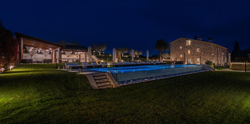 Cornellá de TerriにあるMas Rosset - Luxury Villa Girona - Costa Bravaの夜間のスイミングプール付きハウス