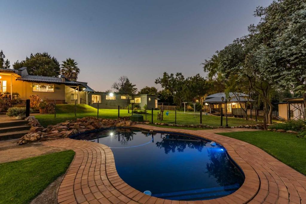 a swimming pool in a yard with a house at Self-Catered Apartment With Pool in Krugersdorp