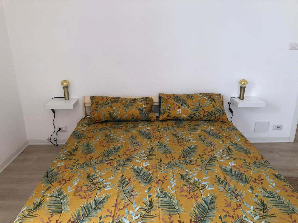 um quarto com uma cama com uma colcha amarela e verde em Casa Mestrina em Mestre