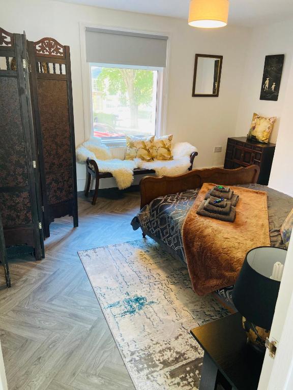 a living room with a bed and a window at Funky cozy cottage with outside space in Eastbourne
