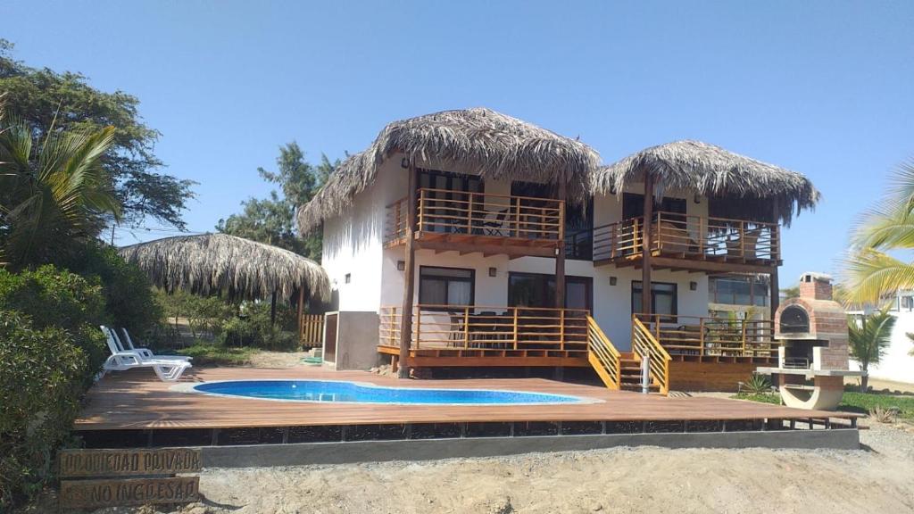 a house with a swimming pool and a resort at Casa Ananda Peru in Los Órganos