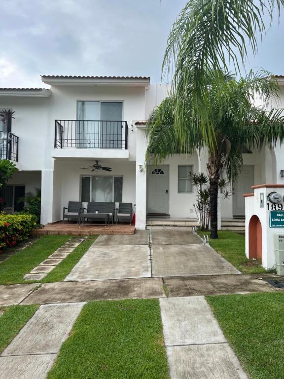 a large white house with a palm tree at Casa Nuevo Vallarta + 2 albercas in Nuevo Vallarta 