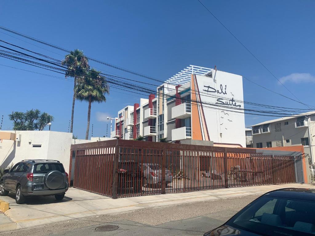 a car parked next to a fence in front of a building at Dali Suites in Tijuana