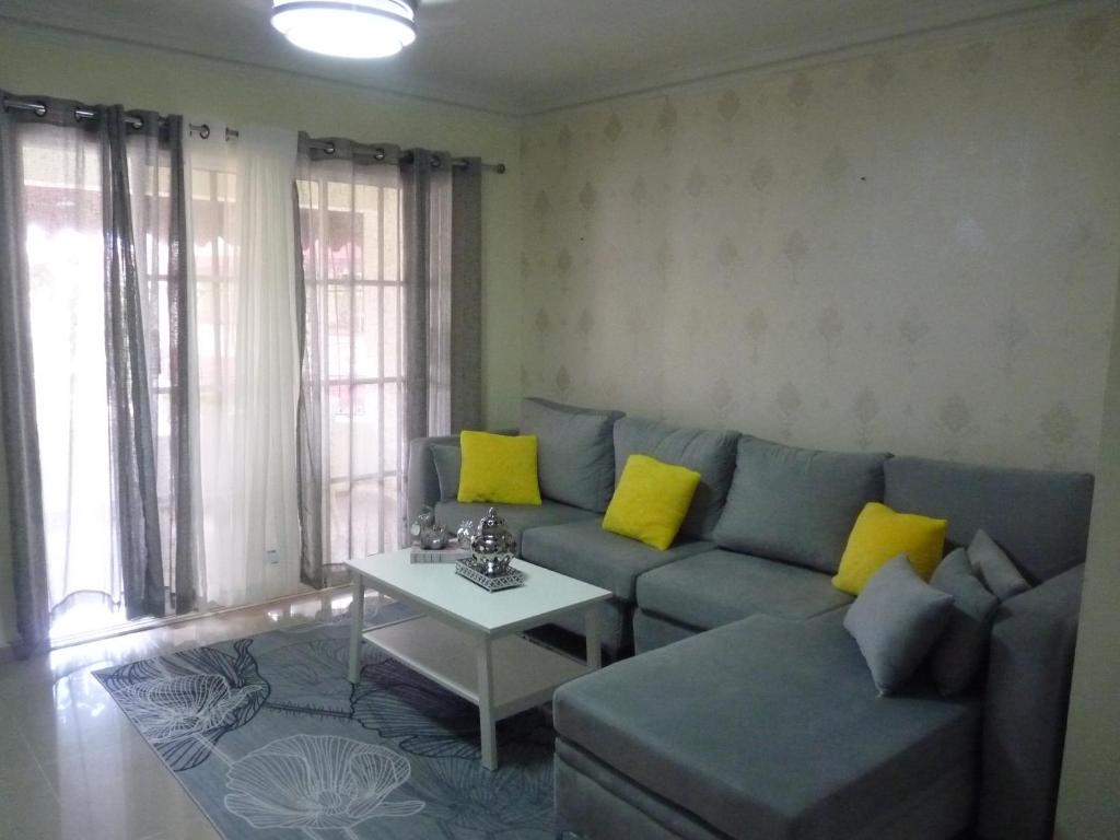 sala de estar con sofá azul y almohadas amarillas en Apartamento luminoso, espacioso y funcional, como en casa, en El Seis